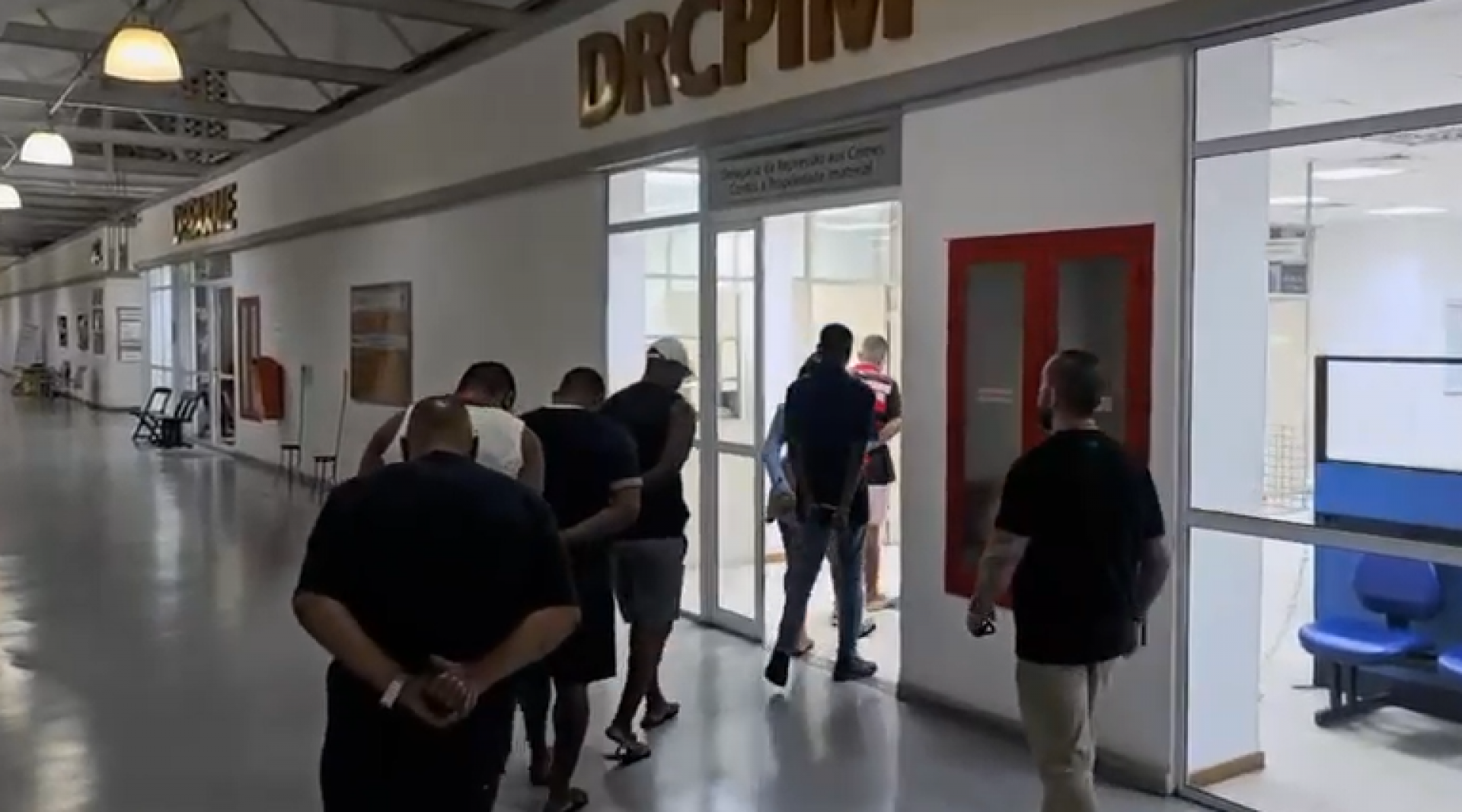 Presos durante a ação chegando à delegacia - Reprodução