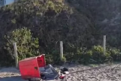 Homem busca abrigo contra o frio dentro de caçamba de lixo na Praia do Forte, em Cabo Frio