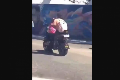 Sem capacete, mulher leva criança na perna em moto elétrica em Cabo Frio
